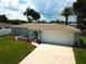Beautiful single-story home showcasing a green lawn, mature trees, vibrant landscaping, and a convenient two-car garage at 7314 Ivanhoe Dr, Port Richey, FL 34668