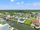 Aerial view of waterfront neighborhood featuring canals, docks, and nearby lush greenery and conservation at 7401 Islander Ln, Hudson, FL 34667