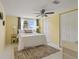 Bright bedroom featuring a comfortable bed, ceiling fan, and natural light at 7401 Islander Ln, Hudson, FL 34667