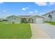 Charming single-story home with a well-manicured lawn, arched entryway, and attached garage at 7401 Islander Ln, Hudson, FL 34667