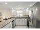 Modern kitchen featuring white cabinets, stainless steel appliances, and ample counter space at 7401 Islander Ln, Hudson, FL 34667