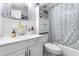 Cozy bathroom with a patterned shower curtain and white vanity at 7441 Cypress Dr, New Port Richey, FL 34653