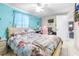 Comfortable bedroom with a floral bedspread, ceiling fan, and blue accent wall at 7441 Cypress Dr, New Port Richey, FL 34653