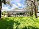 Wide shot of the home's spacious backyard with screened in pool area and lawn at 8834 Whispering Oaks Trl, New Port Richey, FL 34654