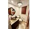Cozy powder room featuring vessel sink, stylish mirror and dark wood door at 8834 Whispering Oaks Trl, New Port Richey, FL 34654