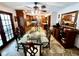 Spacious dining room showcasing a glass table and hardwood cabinets with wine storage at 8834 Whispering Oaks Trl, New Port Richey, FL 34654