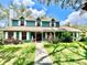 Inviting two-story home with a covered front porch, well-manicured lawn, and beautiful landscaping at 8834 Whispering Oaks Trl, New Port Richey, FL 34654