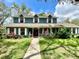 Inviting two-story home with a manicured lawn, mature trees, and a welcoming front porch at 8834 Whispering Oaks Trl, New Port Richey, FL 34654