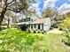 Well-maintained two-story home with lush green lawn, mature trees, and an attached two-car garage at 8834 Whispering Oaks Trl, New Port Richey, FL 34654