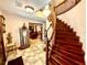 Elegant foyer with wooden staircase, decorative statue and view to formal living room at 8834 Whispering Oaks Trl, New Port Richey, FL 34654