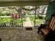 Inviting front porch view with brick flooring, a decorative chair, and manicured landscaping at 8834 Whispering Oaks Trl, New Port Richey, FL 34654
