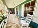 Charming front porch featuring rocking chairs, unique shingle siding, and a tiled floor at 8834 Whispering Oaks Trl, New Port Richey, FL 34654