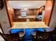Kitchen bar with granite countertop, wooden bar stools and cabinet with blue lighting at 8834 Whispering Oaks Trl, New Port Richey, FL 34654