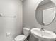 Well-lit half bathroom features a modern pedestal sink, a toilet, and neutral wall paint at 8918 Parsons Hill Blvd, Wesley Chapel, FL 33545