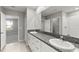 Bathroom featuring double sinks with granite countertops, tile flooring, and a walk-in shower at 8918 Parsons Hill Blvd, Wesley Chapel, FL 33545
