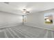 Large bedroom featuring neutral carpet and a ceiling fan with two windows and neutral paint at 8918 Parsons Hill Blvd, Wesley Chapel, FL 33545