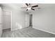 Bedroom with plush gray carpet, ceiling fan, closet, and neutral paint, creating a cozy atmosphere at 8918 Parsons Hill Blvd, Wesley Chapel, FL 33545