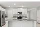 The kitchen has stainless appliances, granite countertops, and white cabinets at 8918 Parsons Hill Blvd, Wesley Chapel, FL 33545