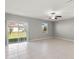 Bright living room features tile floors, a ceiling fan, and sliding glass doors with views of the backyard at 8918 Parsons Hill Blvd, Wesley Chapel, FL 33545