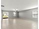 Open living room featuring tile floors, ceiling fan, and natural light from sliding glass doors at 8918 Parsons Hill Blvd, Wesley Chapel, FL 33545