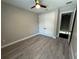 Neutral bedroom with a ceiling fan, closet with double doors, and wood-look flooring at 9005 W Flora St, Tampa, FL 33615