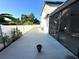 Exterior view of the house showing the side yard, screened-in porch, and white fencing at 9005 W Flora St, Tampa, FL 33615