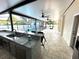 Outdoor kitchen with granite countertops and stainless steel appliances under a screened porch at 9005 W Flora St, Tampa, FL 33615