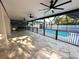 Spacious outdoor patio with ceiling fans, lighting, and an outdoor kitchen overlooking the pool at 9005 W Flora St, Tampa, FL 33615