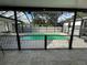 Backyard with a screen enclosed pool, concrete pool deck, and black metal fencing at 9005 W Flora St, Tampa, FL 33615