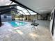Enclosed pool area with brick pavers, a pool, and an outdoor kitchen at 9005 W Flora St, Tampa, FL 33615
