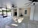 Large screened porch with tile floors, ceiling fans, and doorway to outside area at 9005 W Flora St, Tampa, FL 33615