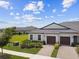 Aerial view of the home featuring mature landscaping, paved driveway, and a well-manicured lawn at 10282 Echo Dock Loop, San Antonio, FL 33576