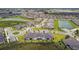 An aerial view of a neighborhood with water views, a roundabout, and modern home designs at 10282 Echo Dock Loop, San Antonio, FL 33576
