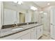 Bright bathroom featuring a dual-sink vanity with granite countertops, tile flooring, and a glass-enclosed shower at 10282 Echo Dock Loop, San Antonio, FL 33576