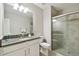 Bathroom with granite countertop, white cabinets, shower, and toilet at 10282 Echo Dock Loop, San Antonio, FL 33576