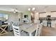 Open dining area with kitchen and living space, natural light, and white wooden table at 10282 Echo Dock Loop, San Antonio, FL 33576
