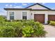 Beautiful home showcasing a lush garden, a brick driveway, and a charming facade at 10282 Echo Dock Loop, San Antonio, FL 33576
