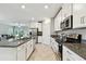Kitchen features stainless steel appliances, white cabinetry, and a granite countertop with a large island at 10282 Echo Dock Loop, San Antonio, FL 33576