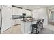 Well-lit kitchen features white cabinets, stainless steel appliances, and a granite island with seating at 10282 Echo Dock Loop, San Antonio, FL 33576