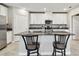 Kitchen features white cabinets, granite countertops, stainless steel appliances, and an island with barstool seating at 10282 Echo Dock Loop, San Antonio, FL 33576