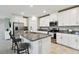 Kitchen with stainless steel appliances, granite countertops, island with barstool seating, and white cabinets at 10282 Echo Dock Loop, San Antonio, FL 33576