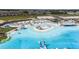 An aerial view of a clear blue lagoon with white sandy beaches and lounge chairs at 10282 Echo Dock Loop, San Antonio, FL 33576