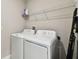 Well lit laundry room with a washer, dryer, overhead storage, and a ladder at 10282 Echo Dock Loop, San Antonio, FL 33576