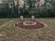A backyard fire pit features two chairs, a brick-lined pit, and wood chip ground cover at 10287 Fordham St, Spring Hill, FL 34608