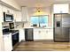 Modern kitchen featuring stainless steel appliances, white cabinets, and a stylish backsplash at 10287 Fordham St, Spring Hill, FL 34608