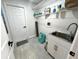 Functional laundry area with a sink, storage shelves, and space for laundry appliances at 10287 Fordham St, Spring Hill, FL 34608