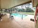Inviting pool area with a screened-in enclosure, bar table, and seating, perfect for outdoor relaxation at 10287 Fordham St, Spring Hill, FL 34608