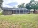 View of screened-in pool area with backyard seating, perfect for entertaining at 10287 Fordham St, Spring Hill, FL 34608