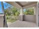 Balcony view showcasing lush greenery and blue skies from a covered patio with gray tile flooring at 10399 Boyette Brook St, Riverview, FL 33569