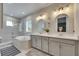 Modern bathroom with double vanity, framed mirrors, walk-in shower, and soaking tub at 10399 Boyette Brook St, Riverview, FL 33569